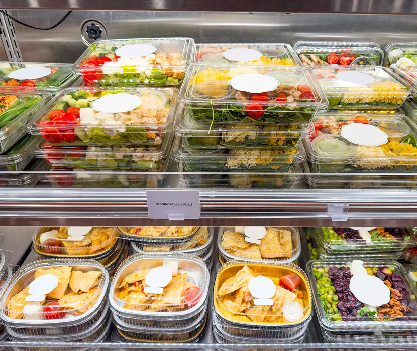 Packaged salads and meals in a display.