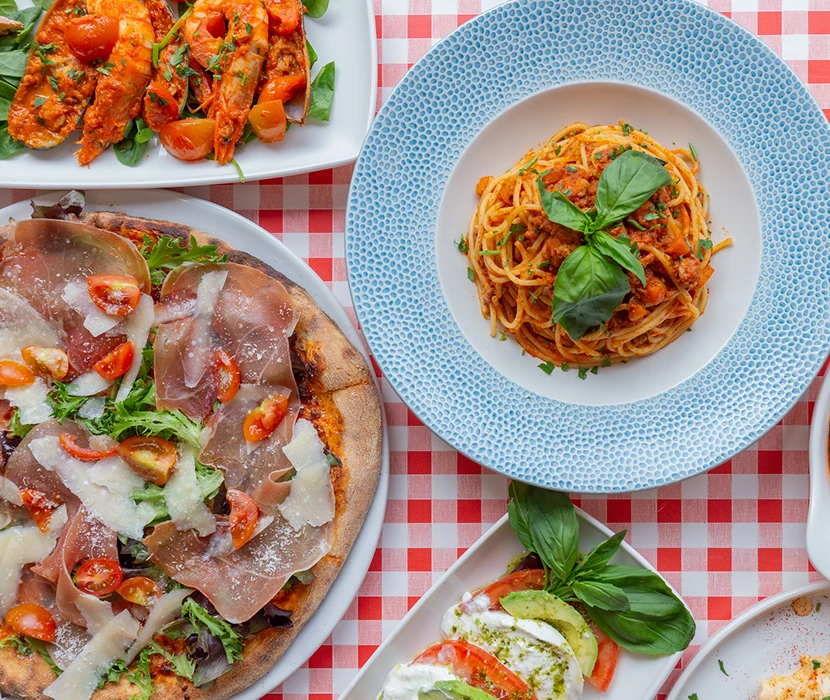 Italian dishes on a checkered tablecloth.